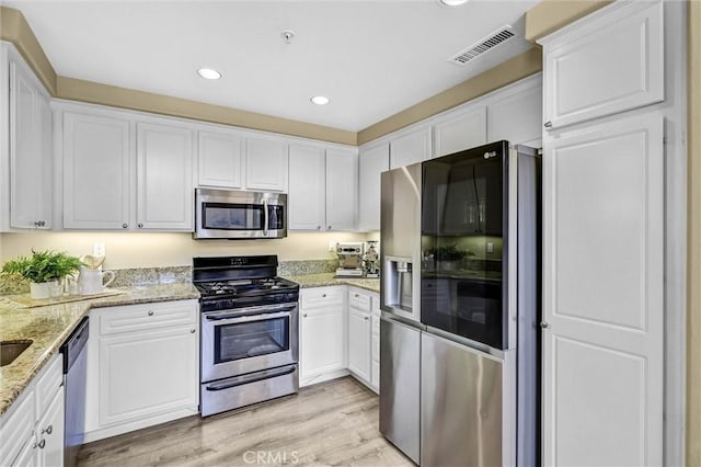 2641 Dunstan Dr, Tustin, CA 92782 - kitchen featuring visible vents, appliances with stainless steel finishes, light wood finished floors, recessed lighting, and white cabinetry