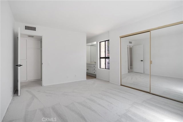 2240 S Palm Canyon Dr Unit 20, Palm Springs, CA 92264 - unfurnished bedroom featuring light colored carpet, connected bathroom, and a closet