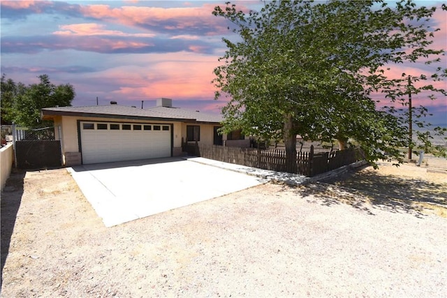 single story home featuring stucco siding, a garage, fence, and concrete driveway