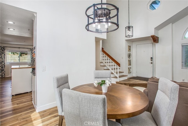 dining space with baseboards, recessed lighting, stairs, and wood finished floors