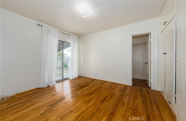 unfurnished bedroom with access to outside and light wood-style flooring