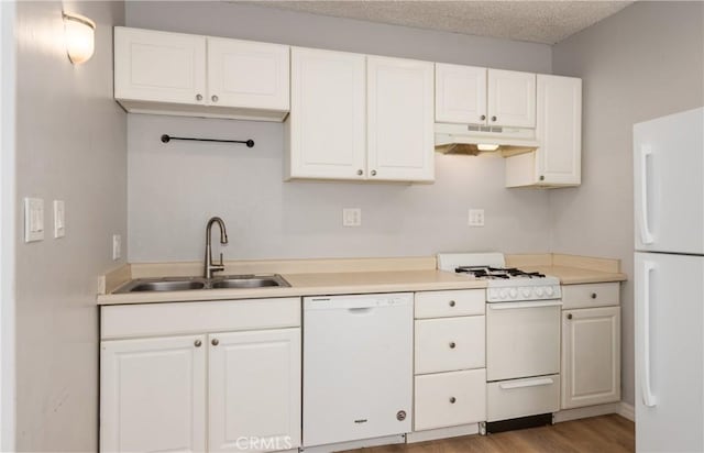 kitchen with a sink, white cabinets, under cabinet range hood, and white appliances