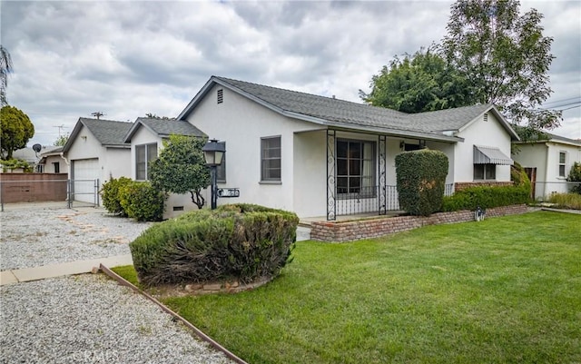 ranch-style home with fence, stucco siding, an attached garage, and a front yard