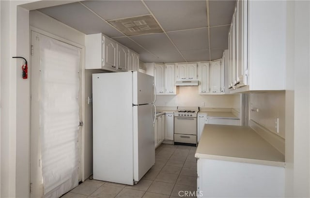 kitchen featuring white appliances, visible vents, a paneled ceiling, and light tile patterned floors
