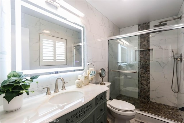 full bathroom with a marble finish shower, vanity, and toilet