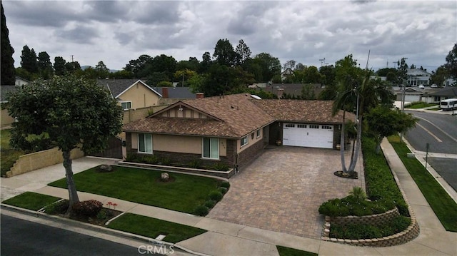 view of front of property with a residential view, an attached garage, a front lawn, stucco siding, and decorative driveway