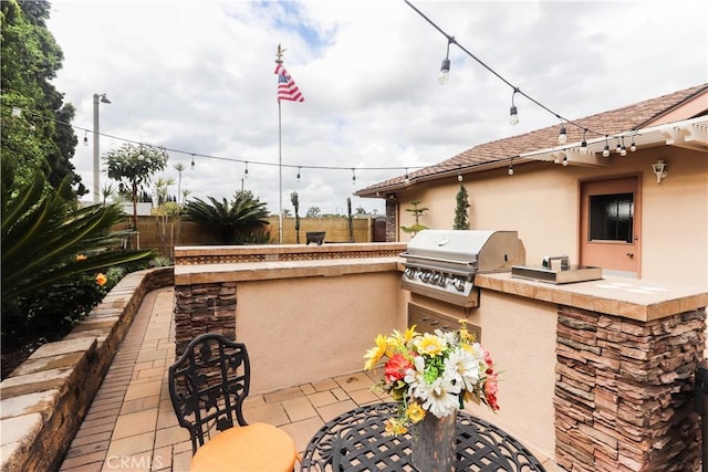 view of patio featuring a fenced backyard, exterior kitchen, and a grill
