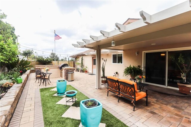 view of patio / terrace with fence, outdoor dry bar, an outdoor living space, and grilling area