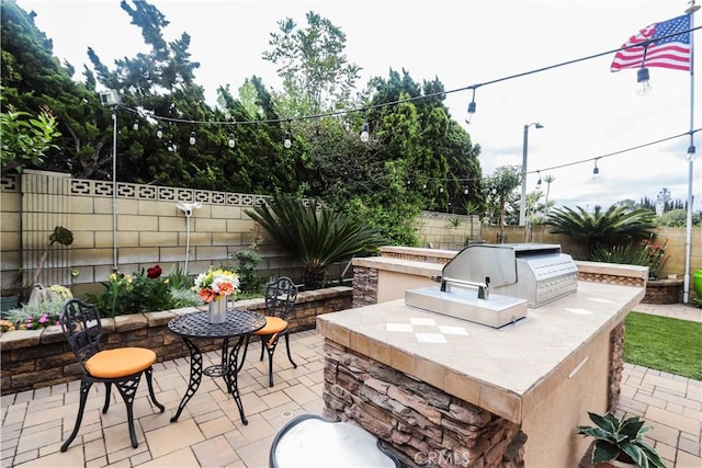 view of patio featuring exterior kitchen and a fenced backyard