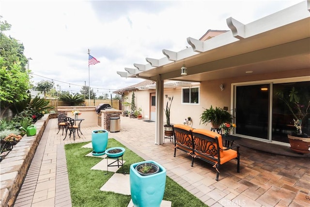 view of patio featuring fence, outdoor dry bar, grilling area, and outdoor lounge area