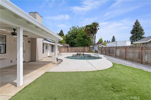 view of yard with a fenced in pool, a fenced backyard, ceiling fan, and a patio area