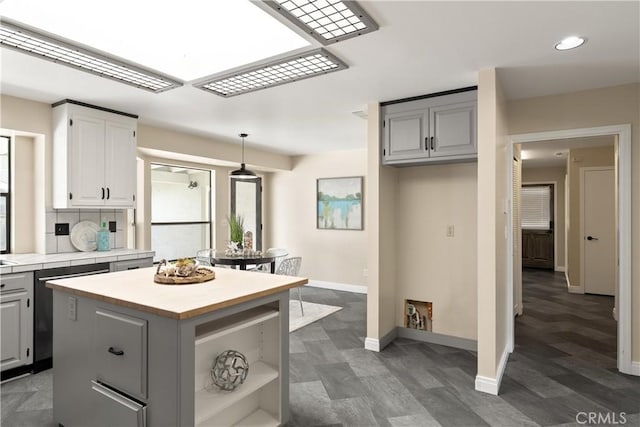 kitchen with a center island, recessed lighting, baseboards, tile countertops, and gray cabinetry