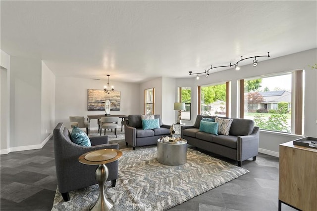 living area featuring baseboards and a chandelier