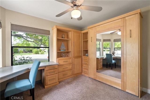 office area featuring built in study area, carpet, and ceiling fan