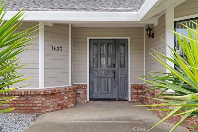 1635 Almendia Dr, Chico, CA 95926 - entrance to property with roof with shingles, brick siding, and covered porch