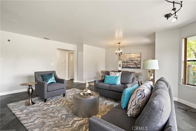 living area featuring baseboards, visible vents, and a chandelier