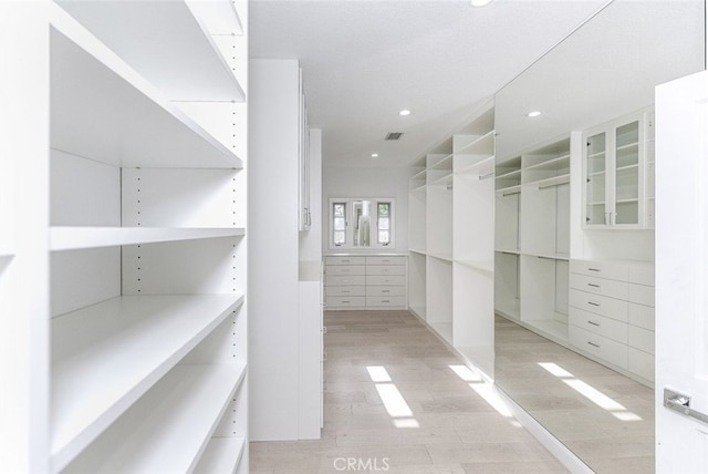 spacious closet featuring light wood-style floors and visible vents
