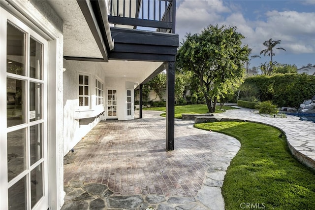 view of patio featuring french doors and a balcony