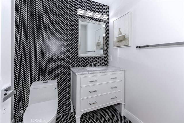 half bathroom featuring toilet, tile walls, tile patterned flooring, and vanity