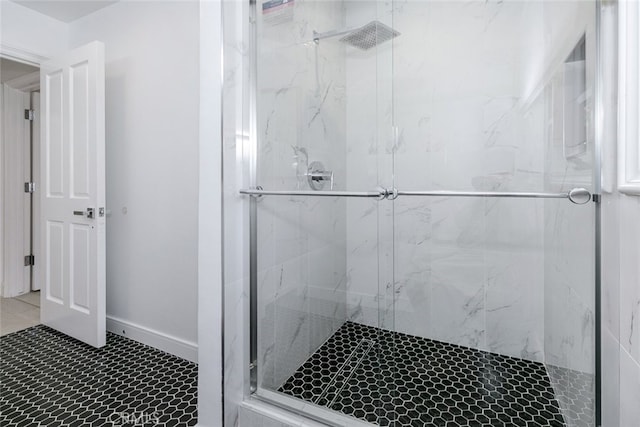 bathroom with tile patterned floors and a marble finish shower