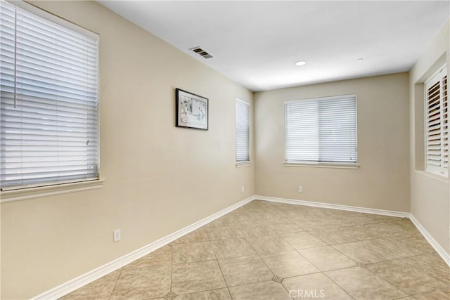 unfurnished room featuring baseboards, light tile patterned flooring, and visible vents
