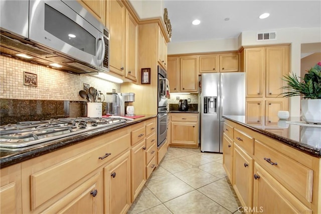 kitchen with decorative backsplash, visible vents, appliances with stainless steel finishes, dark stone countertops, and light brown cabinets