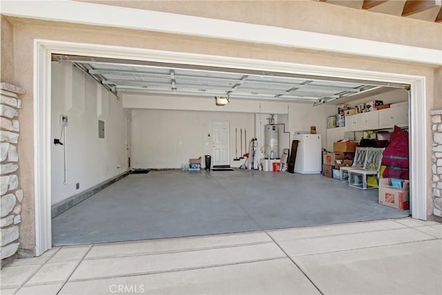 garage featuring fridge, water heater, and electric panel