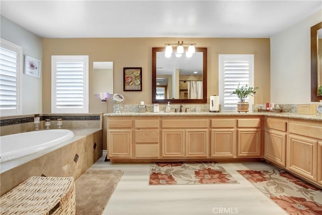 full bathroom featuring a shower with curtain, vanity, a garden tub, and a wealth of natural light