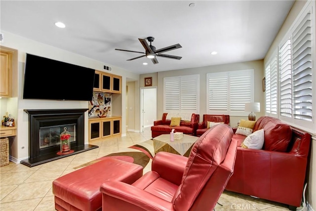 living area with recessed lighting, ceiling fan, a glass covered fireplace, and tile patterned flooring