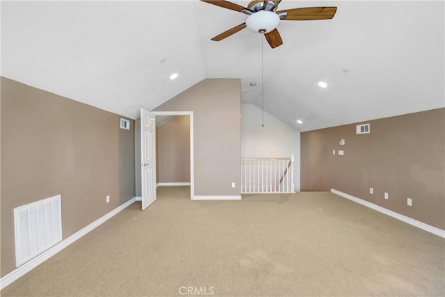 additional living space featuring vaulted ceiling, a ceiling fan, light colored carpet, and visible vents