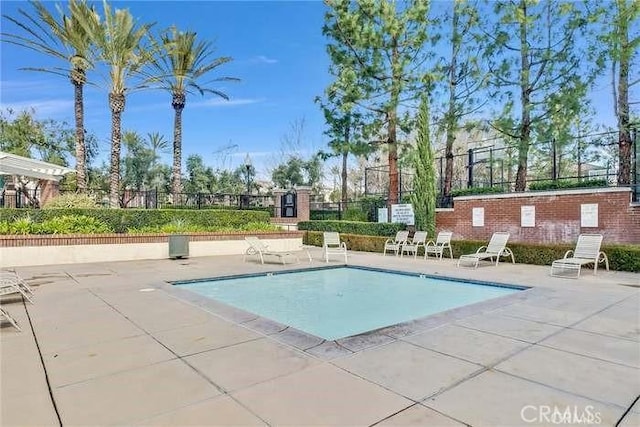community pool featuring a patio and fence