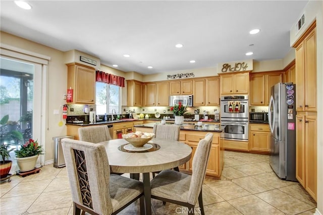 kitchen featuring recessed lighting, a sink, appliances with stainless steel finishes, and light tile patterned floors