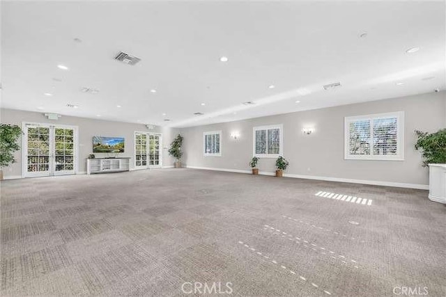 unfurnished living room with visible vents, carpet, and baseboards