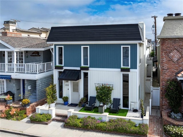 view of front of home featuring metal roof and a shingled roof