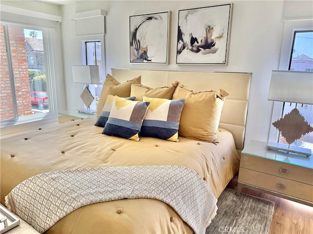 bedroom featuring multiple windows and wood finished floors