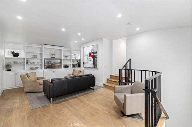 living room featuring light wood-style floors, stairway, and recessed lighting
