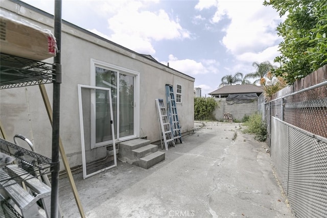 exterior space with a patio, a fenced backyard, stucco siding, and entry steps