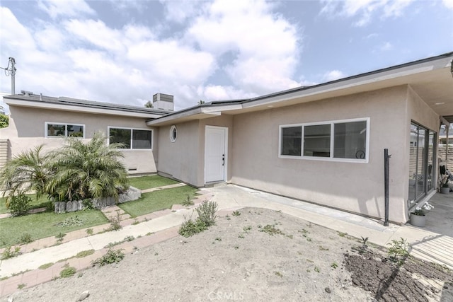 back of house with a patio area and stucco siding