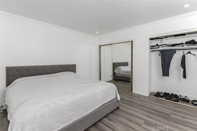 bedroom with crown molding, recessed lighting, baseboards, and wood finished floors