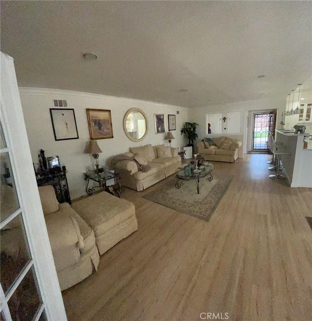 19522 Caney Ave, Carson, CA 90746 - living room with visible vents, light wood finished floors, and crown molding