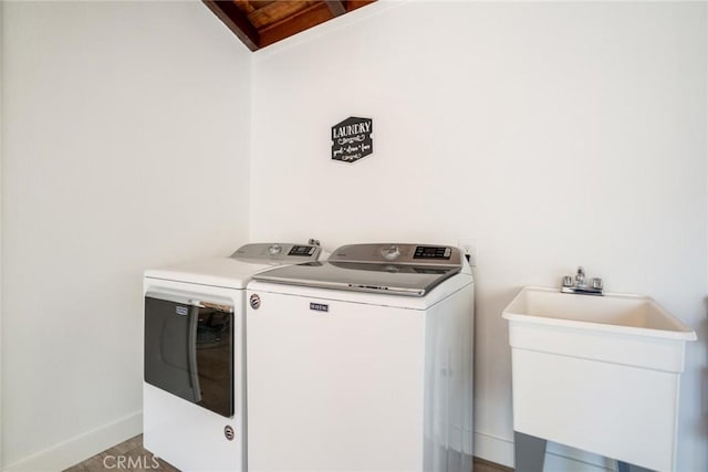 laundry room with a sink, baseboards, laundry area, and washer and dryer