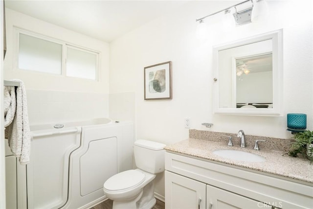 full bathroom featuring vanity, a garden tub, and toilet