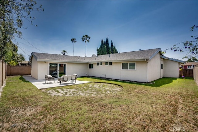 back of house with a fenced backyard, a patio area, stucco siding, and a yard