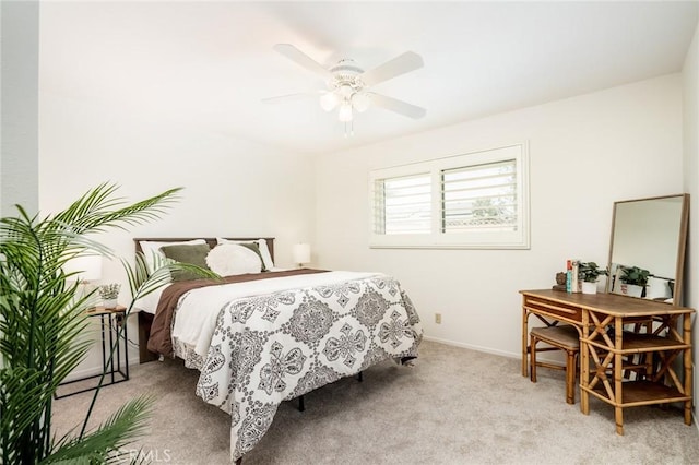 bedroom with a ceiling fan, baseboards, and light colored carpet