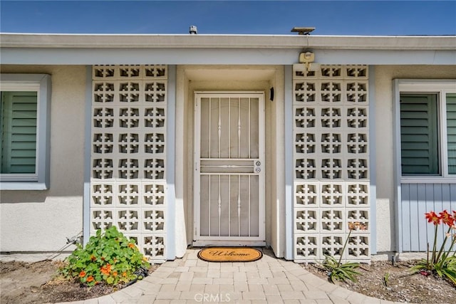 property entrance with stucco siding