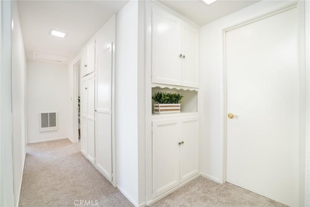 hallway featuring visible vents and light carpet