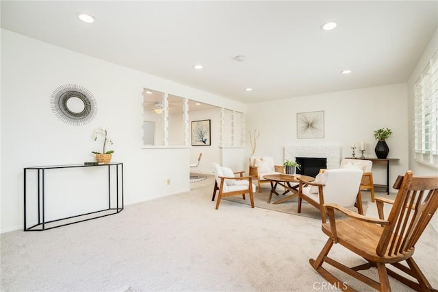 sitting room with a fireplace, recessed lighting, and light colored carpet