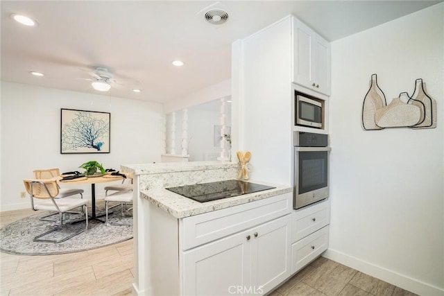 kitchen featuring visible vents, baseboards, ceiling fan, white cabinets, and appliances with stainless steel finishes