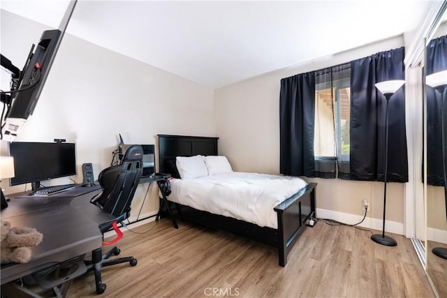 bedroom featuring baseboards and wood finished floors