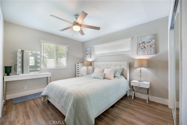 bedroom featuring a ceiling fan, baseboards, and wood finished floors
